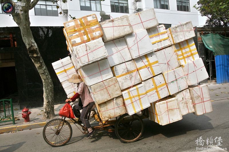 2006年10月，中国上海。一位蹬自行车的女人，载着一车的泡沫箱。